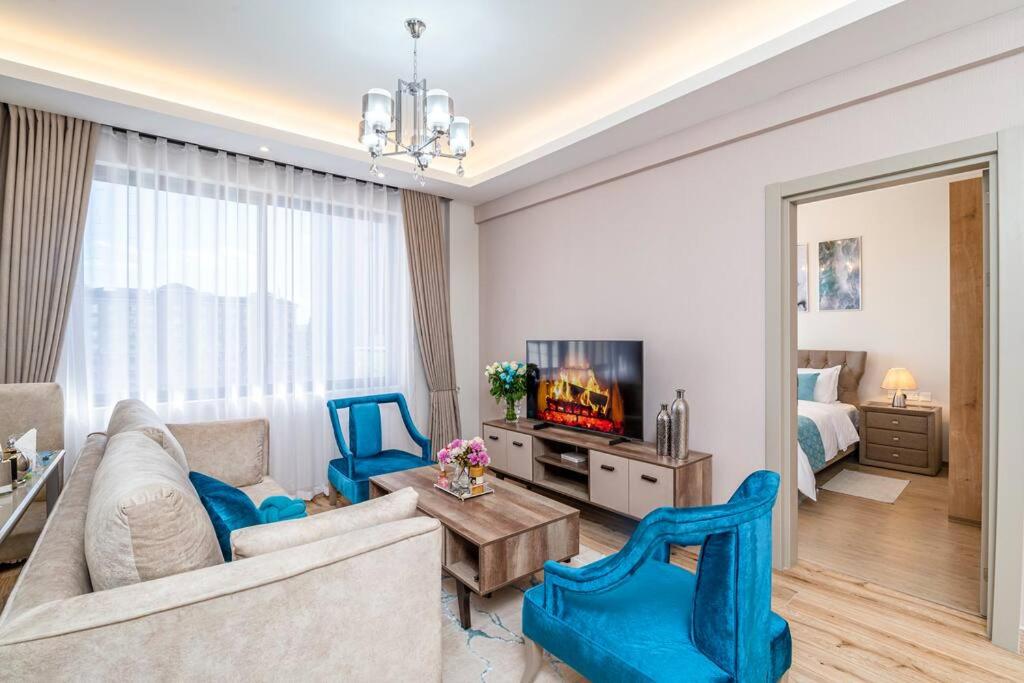 Una sala de estar con un sofá y un televisor. en A cozy and elegant apartment, en Nairobi