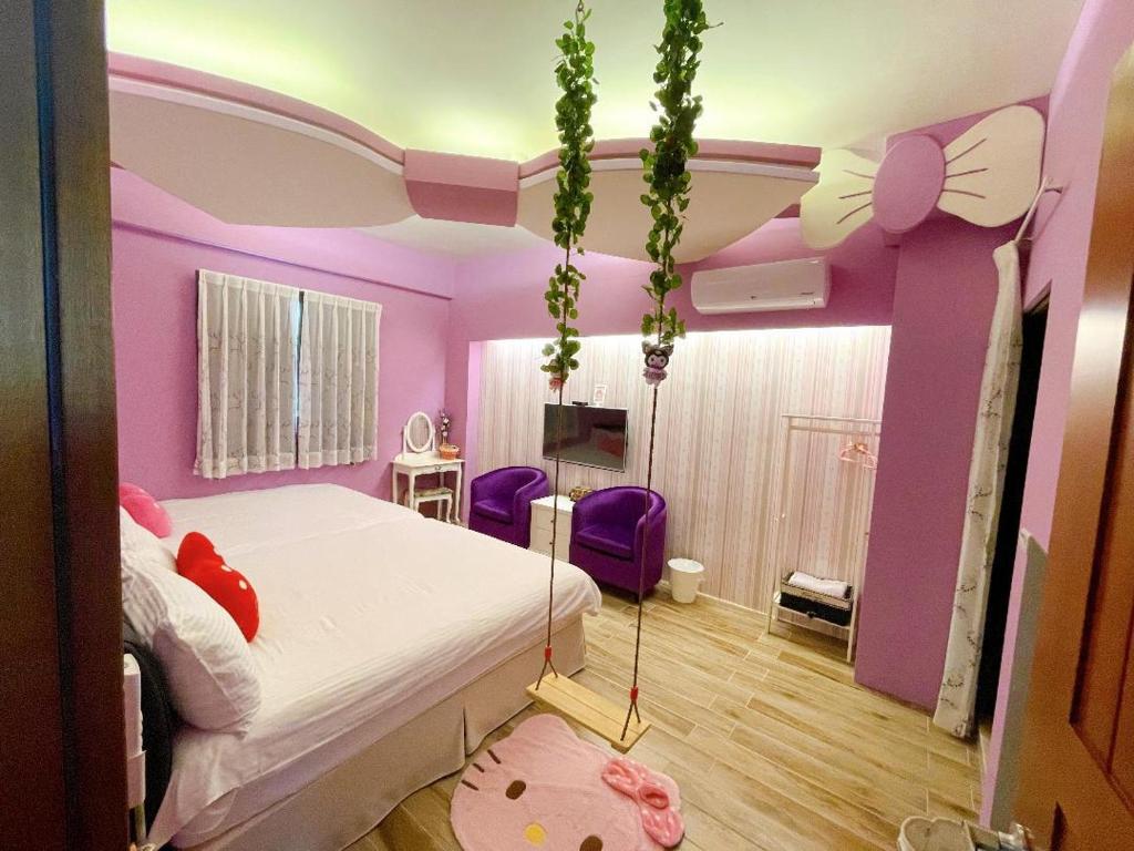 a bedroom with a bed in a pink room at Misto B&amp;B in Taitung City