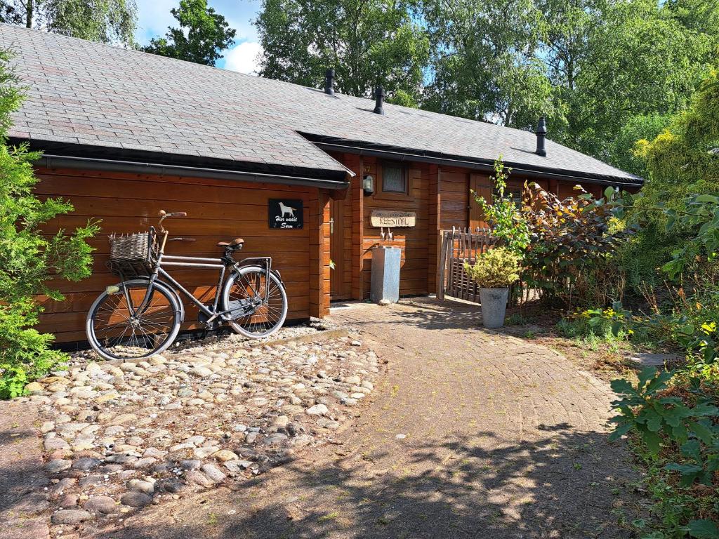 una bicicleta estacionada frente a una cabaña en Buitenplaats Reestdal, en IJhorst