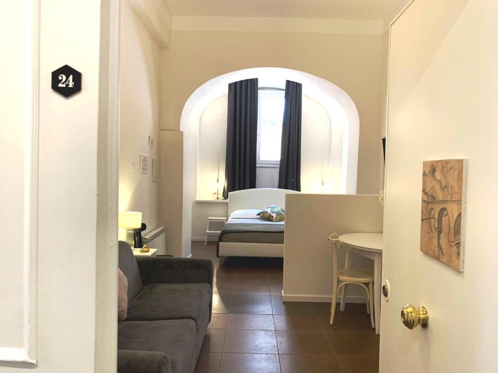 een woonkamer met een bank en een slaapkamer bij Eccelso Suites in Rome