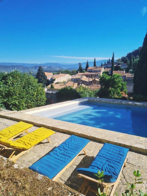 une piscine avec deux chaises longues à côté dans l'établissement Le Clos des Merveilles, à Rognes
