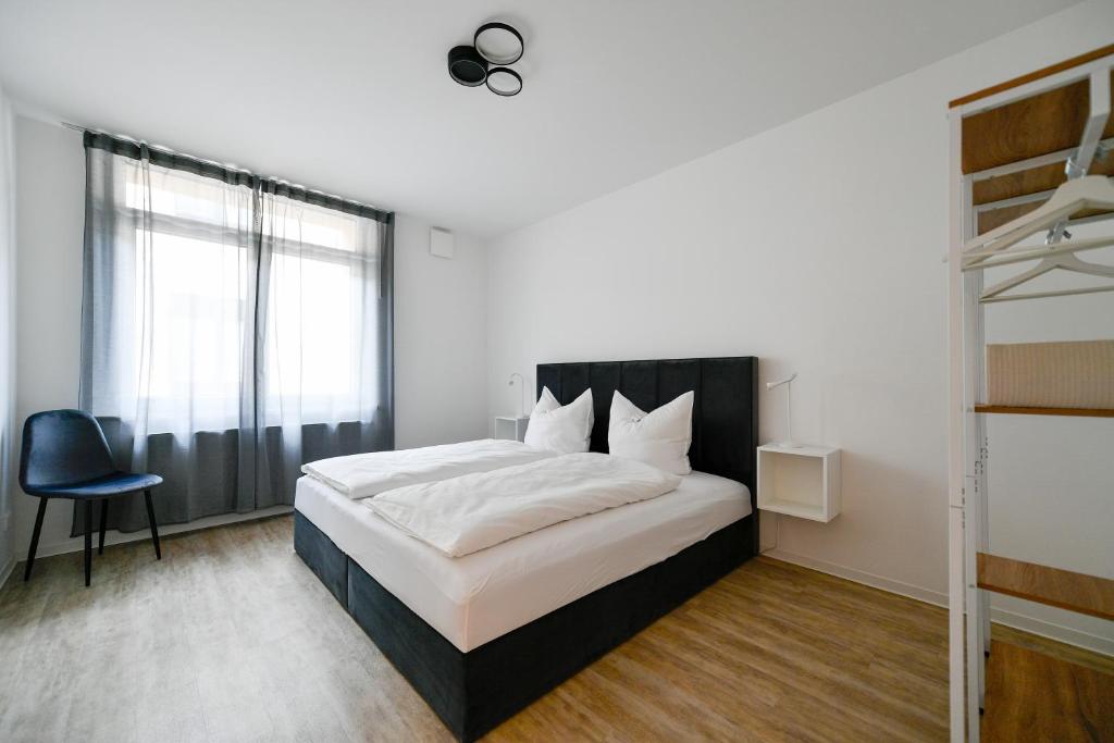 - une chambre avec un grand lit et une fenêtre dans l'établissement Ferienwohnungen am Theater - modern, zentral und ruhig mit Küche, Waschtrockner, Netflix, Wlan und Parkplatz- 2 Zimmer, 52 qm, à Cottbus