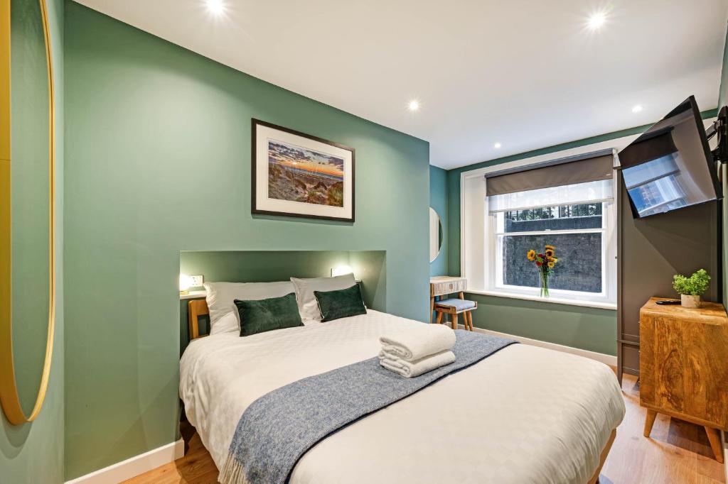 利物浦的住宿－Host & Stay - Catharine Quarters，一间卧室设有一张大床和绿色的墙壁
