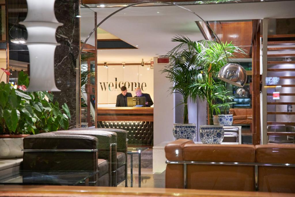 a lobby of a restaurant with a man sitting at a desk at Hotel Plaza in Mestre