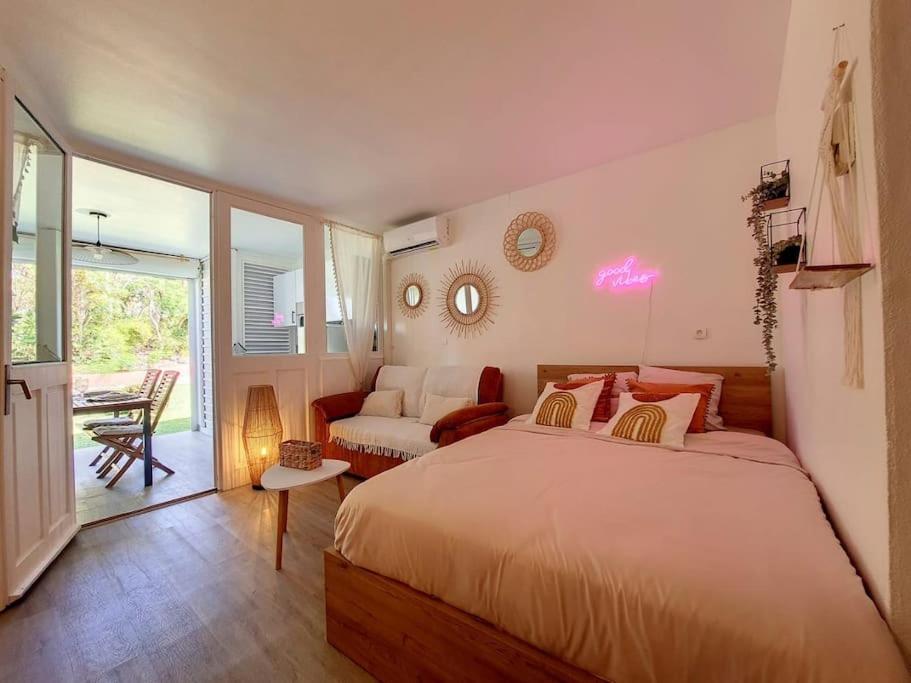 um quarto com uma cama e uma sala de estar em Ty Kinoleta Anse des rochers em Saint-François