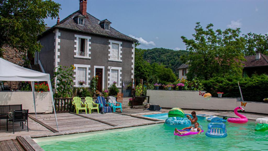 una piscina en el patio trasero con gente en el agua en Carpe Diem Bed and Breakfast, en Beaulieu-sur-Dordogne