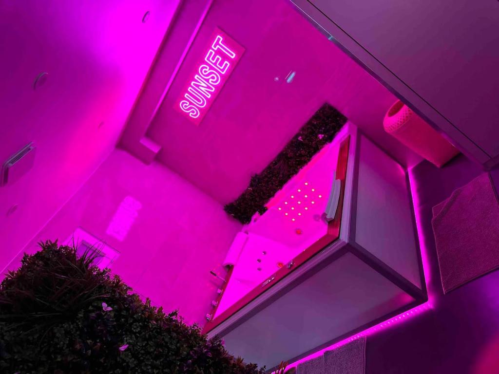 a pink room with a sign that says exit at La Suite Sun Set in Tremblay-En-France