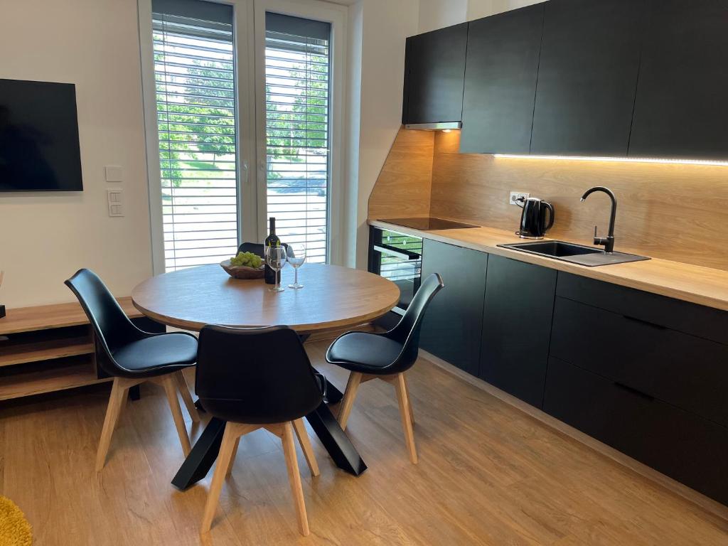 a kitchen with a table and chairs and a sink at Apartmány Kyjov in Kyjov