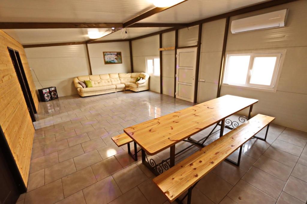 a large room with a wooden table and a couch at Valea Fazanilor in Durleşti