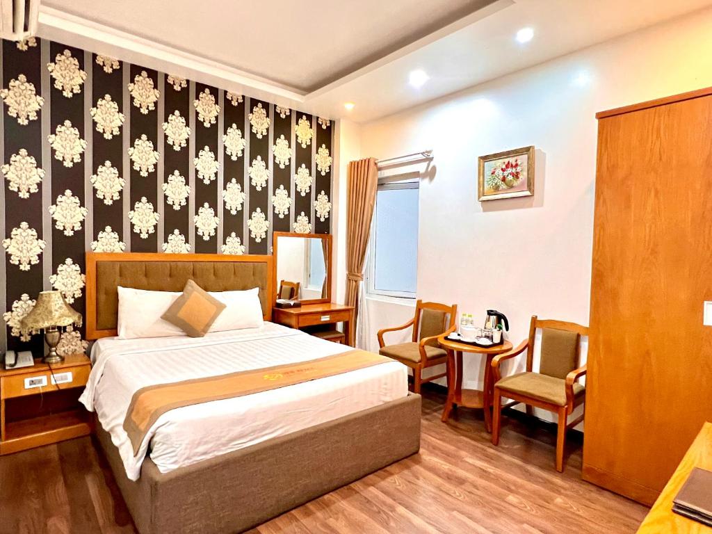 a hotel room with a bed and two chairs at New Space Hotel Airport in Ho Chi Minh City