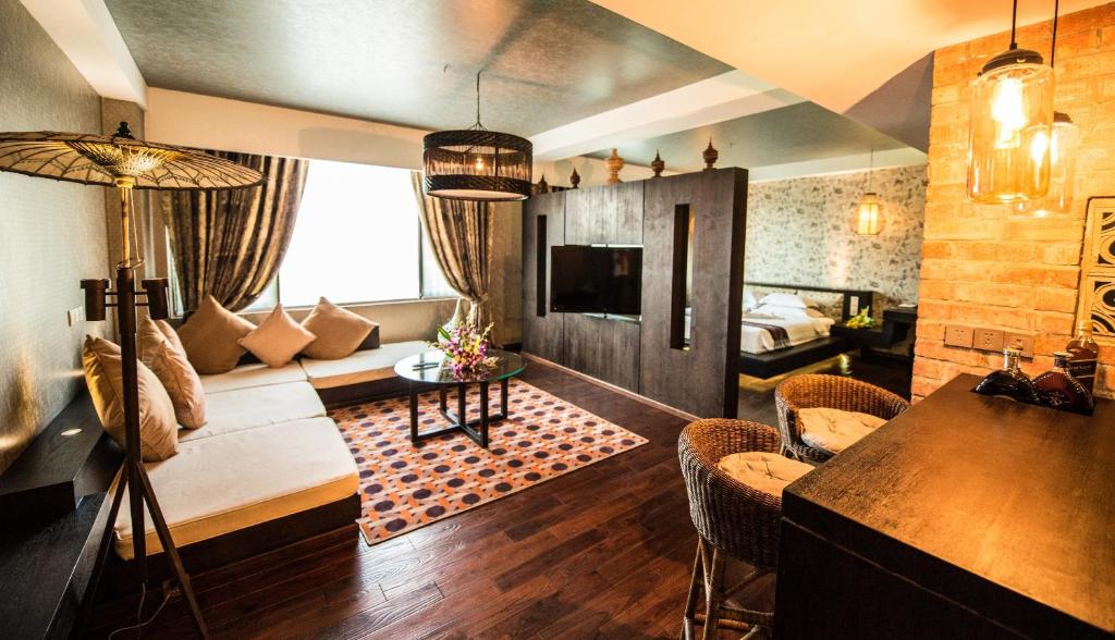 a living room with a couch and a table at Rose Garden Hotel in Yangon