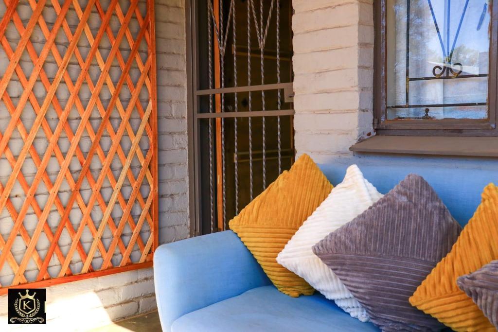 eine blaue Couch auf einer Veranda mit Kissen in der Unterkunft KO'THABENG GUESTHOUSE in Lebowakgomo