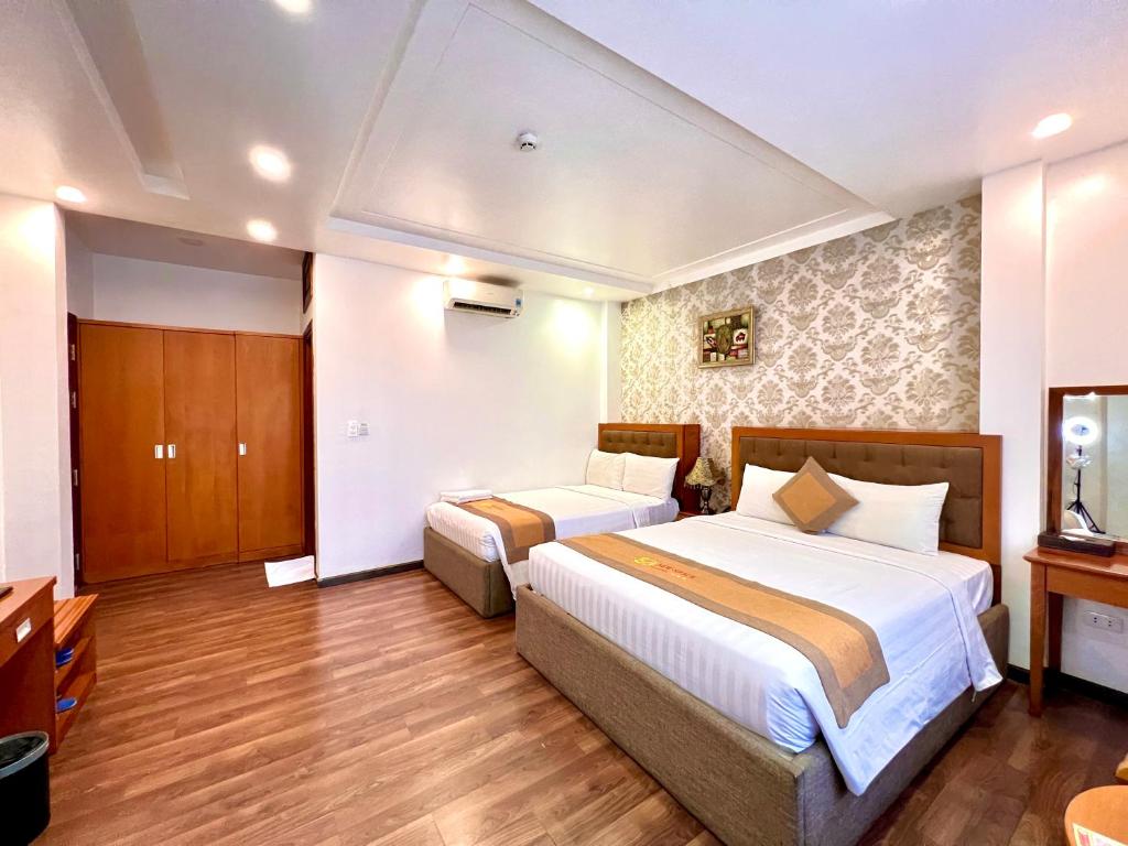 a hotel room with two beds and a television at New Space Hotel Airport in Ho Chi Minh City