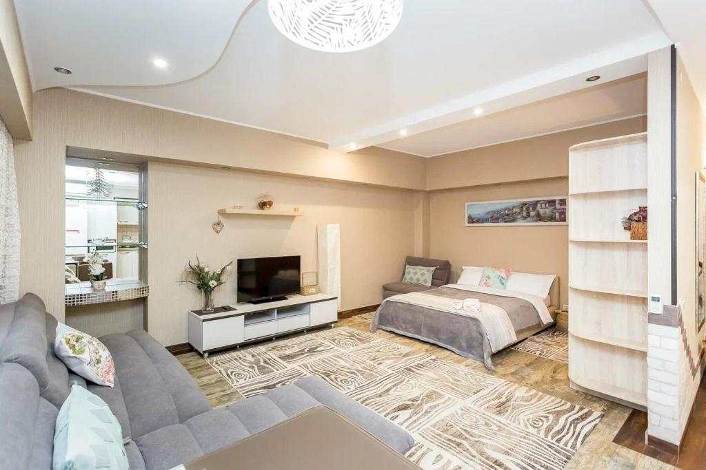 a living room with a couch and a bed at Арбат in Almaty