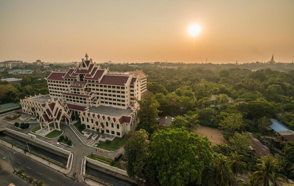 een luchtzicht op een gebouw met een zonsondergang op de achtergrond bij Rose Garden Hotel in Yangon