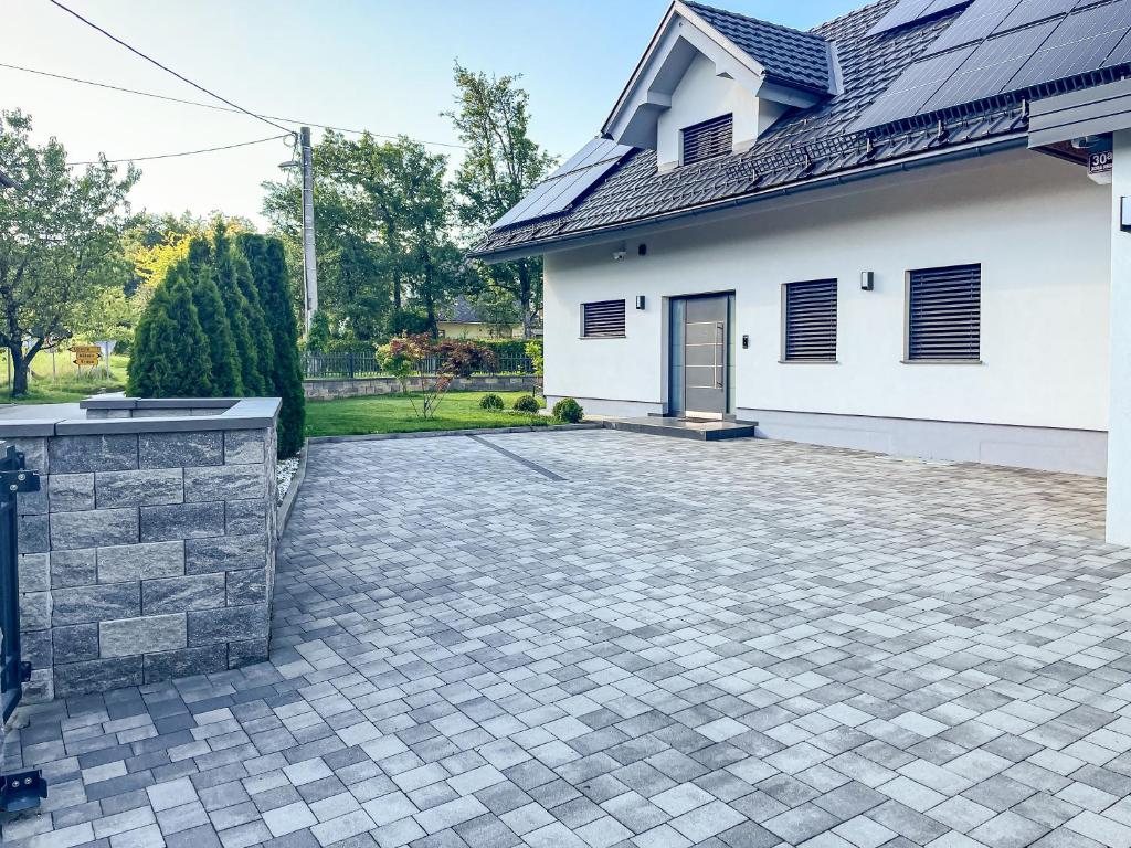 a driveway in front of a white house at Rooms Minka in Kamna Gorica