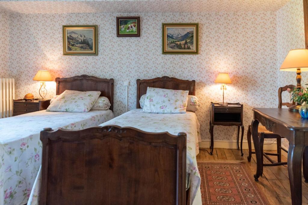 a bedroom with two beds and a desk at La Maison de Mireille in Le Puy-en-Velay