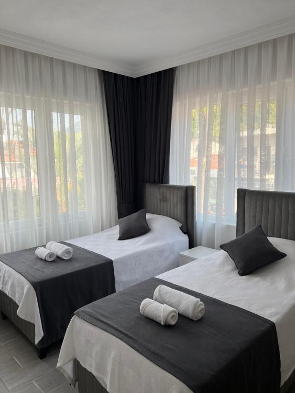 2 bedden in een hotelkamer met ramen bij Moni Homes in Fethiye