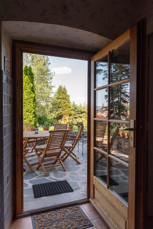 an open door to a patio with a table and chairs at La Maison de Mireille in Le Puy-en-Velay