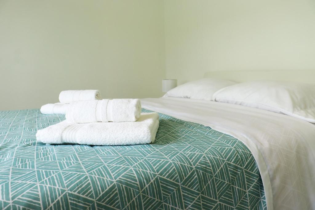 dos pilas de toallas sentadas encima de una cama en Casa do Bairro en Horta
