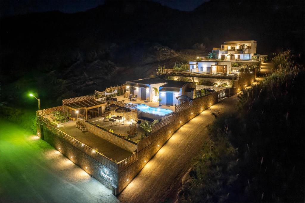 a large house with lights on a hill at night at Mnḗmē Suites & Villas in Kastrí