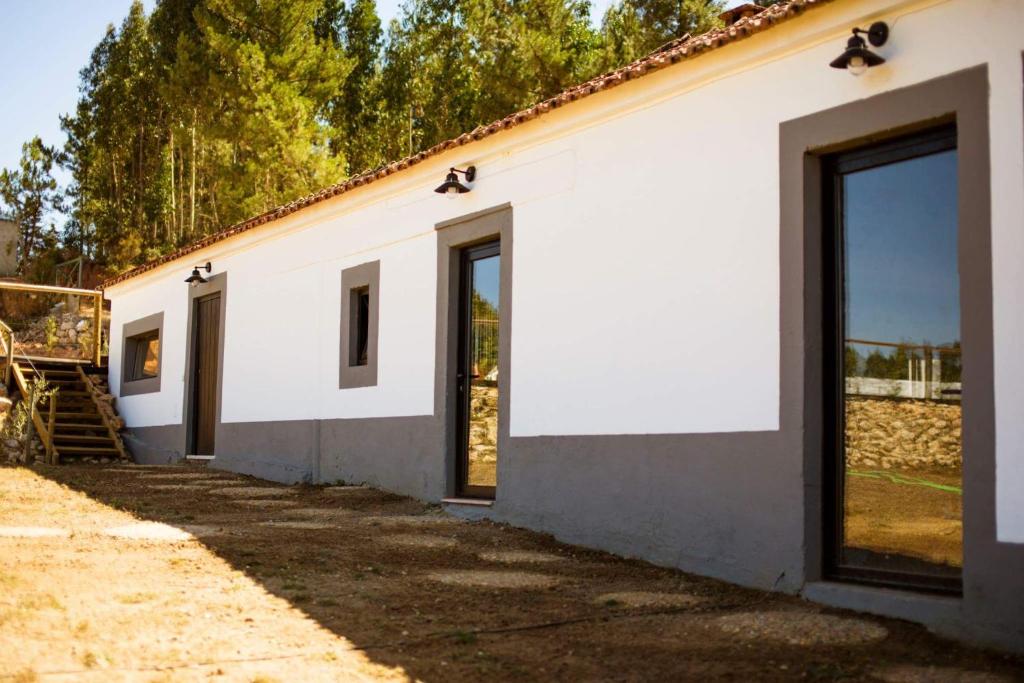 Casa do Caseiro في Sobrena: مبنى أبيض عليه أبواب ونوافذ