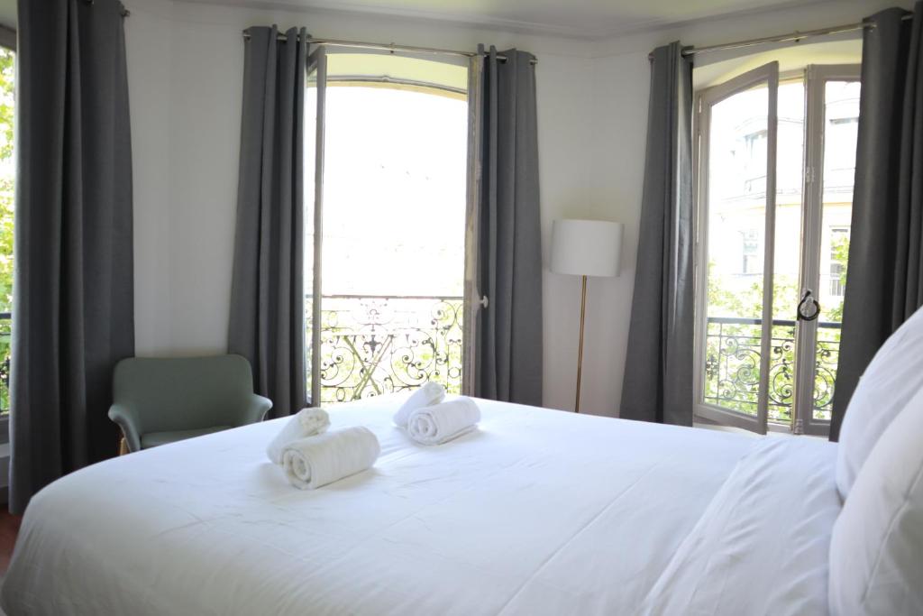 une chambre avec un grand lit blanc avec deux serviettes dans l'établissement Appart 6pers#Châtelet#Les Halles#Rivoli, à Paris