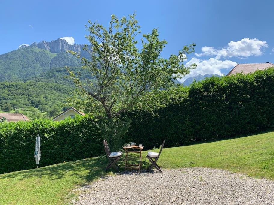 een tafel en twee stoelen in een tuin bij Tranquil apartment surrounded by nature & golf in Écharvine