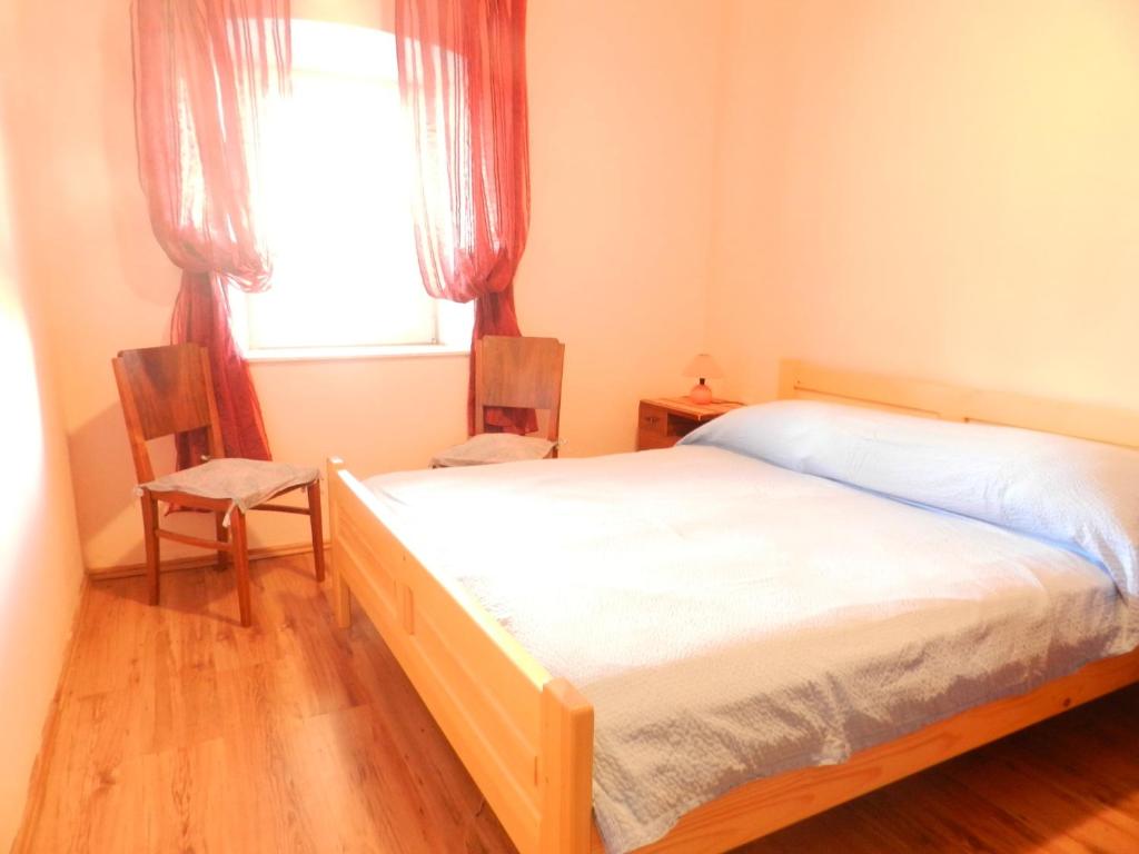ein Schlafzimmer mit einem Bett und einem Fenster in der Unterkunft Apartment Deni in Lumbarda