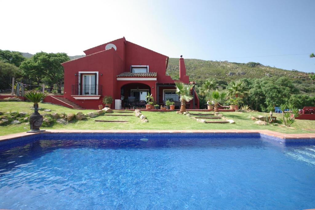 uma casa com piscina em frente a uma casa em Villa Victoria con piscina em Tarifa
