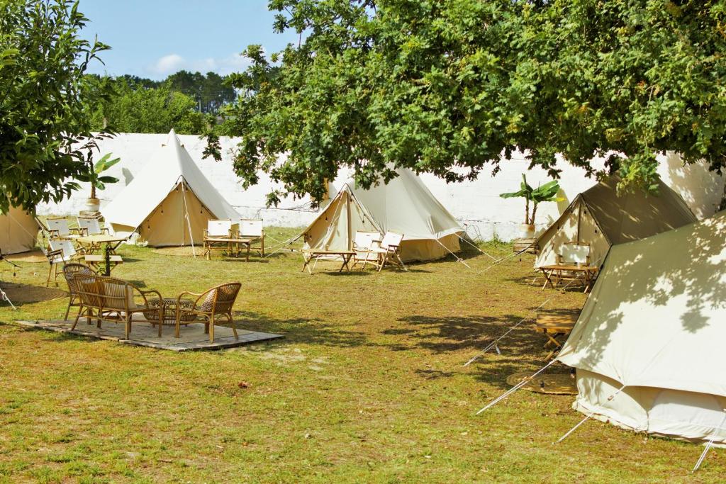 Rianjo的住宿－Kampaoh Rianxo，草原上一组配有桌椅的帐篷