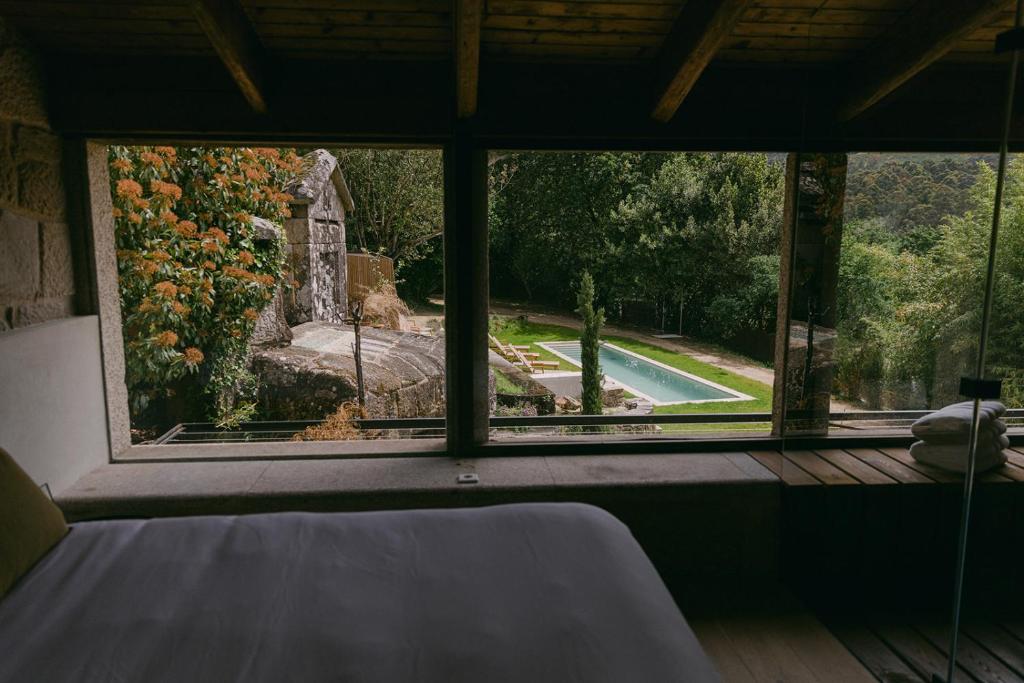 a room with a large window looking out at a yard at Numa Experimental in Pontevedra