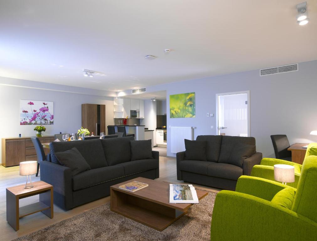 a living room with two couches and a table at Thon Residence Florence Aparthotel in Brussels