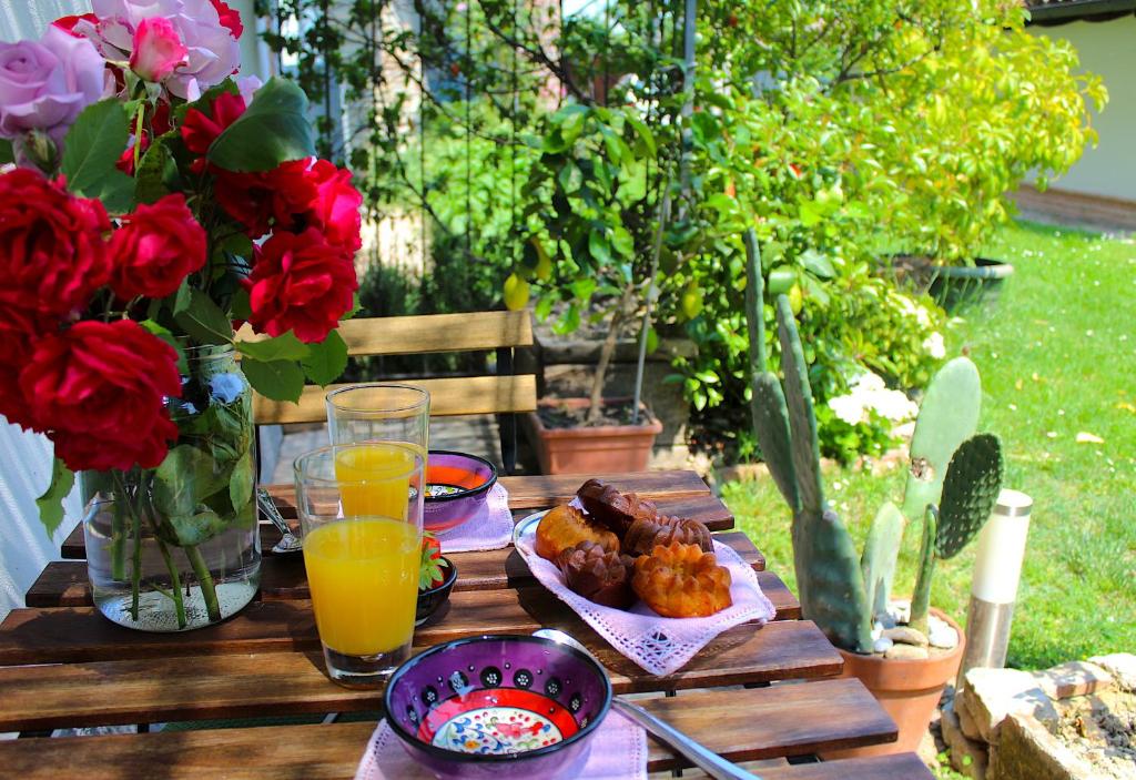a wooden table with food and drinks and flowers at AMAZING LANGHE AND MONFERRATO | House with garden in Calamandrana