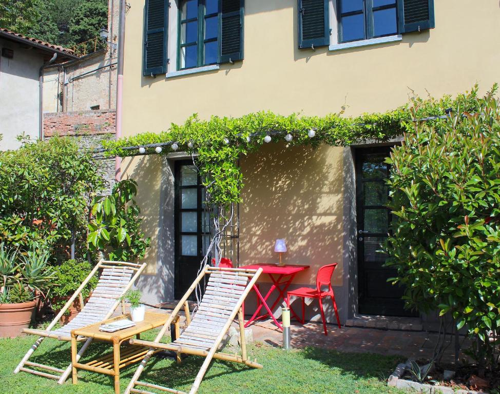 una mesa y sillas frente a una casa en AMAZING LANGHE AND MONFERRATO | House with garden en Calamandrana