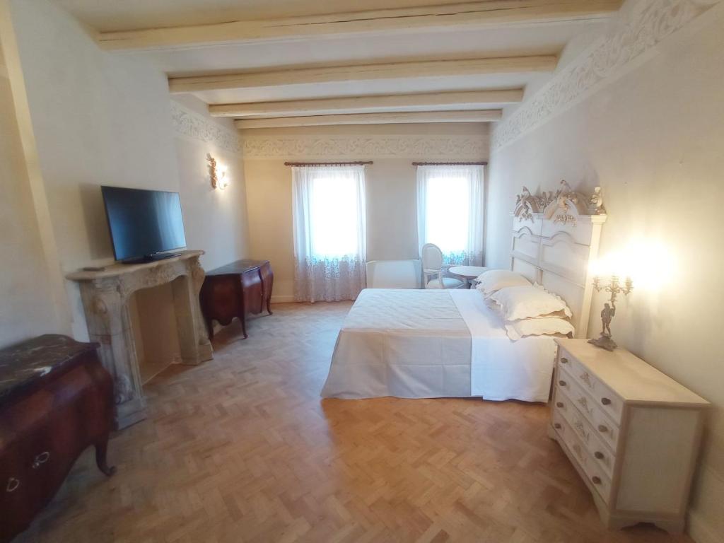 una grande camera da letto con un letto e una televisione di Hotel Oviv dimora del borgo ad Acquaviva Picena