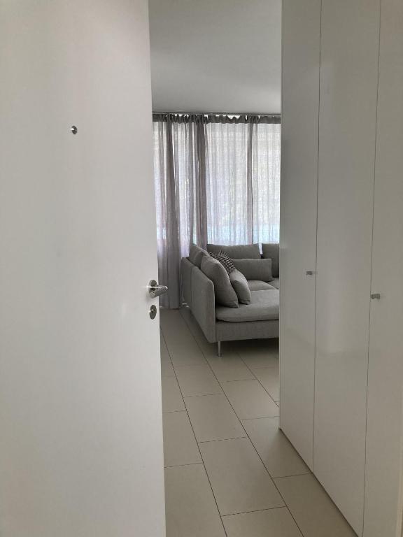 a white living room with a couch and a window at Dolcevita Locarno in Locarno