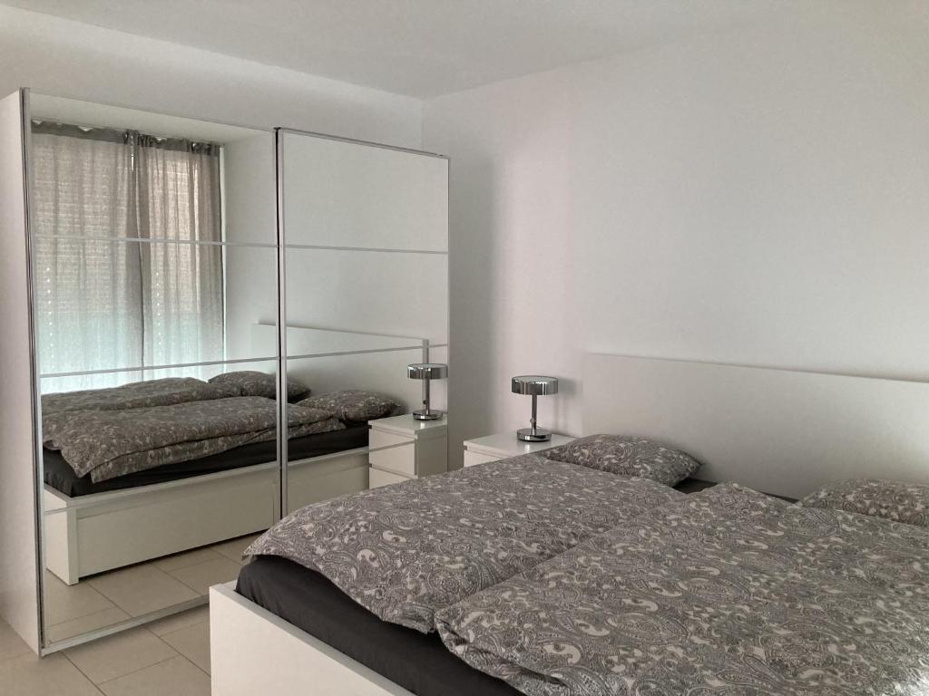 Dolcevita Locarno في لوكارنو: غرفة نوم بسريرين ومرآة