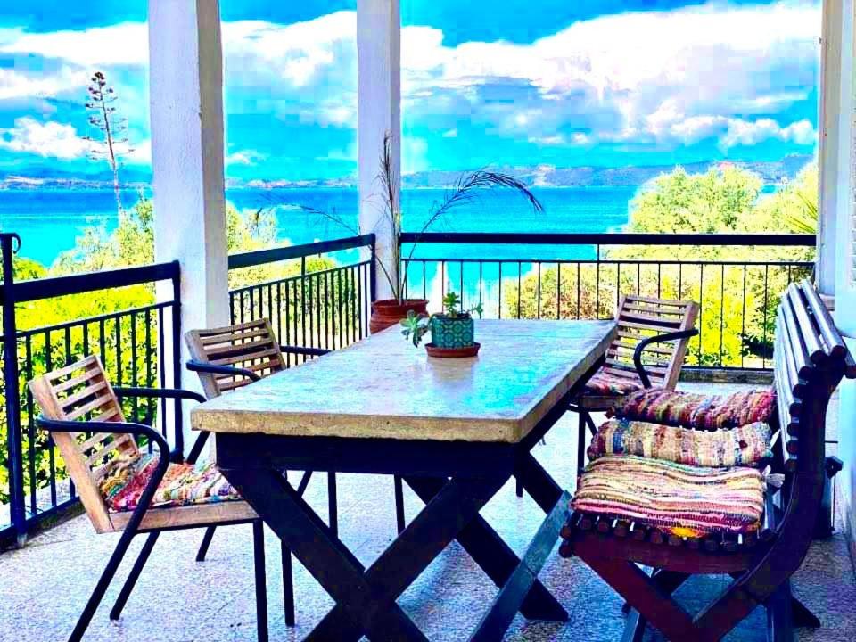 einen Tisch und Stühle auf einer Veranda mit Meerblick in der Unterkunft Casa Santa Agua in Amolianí