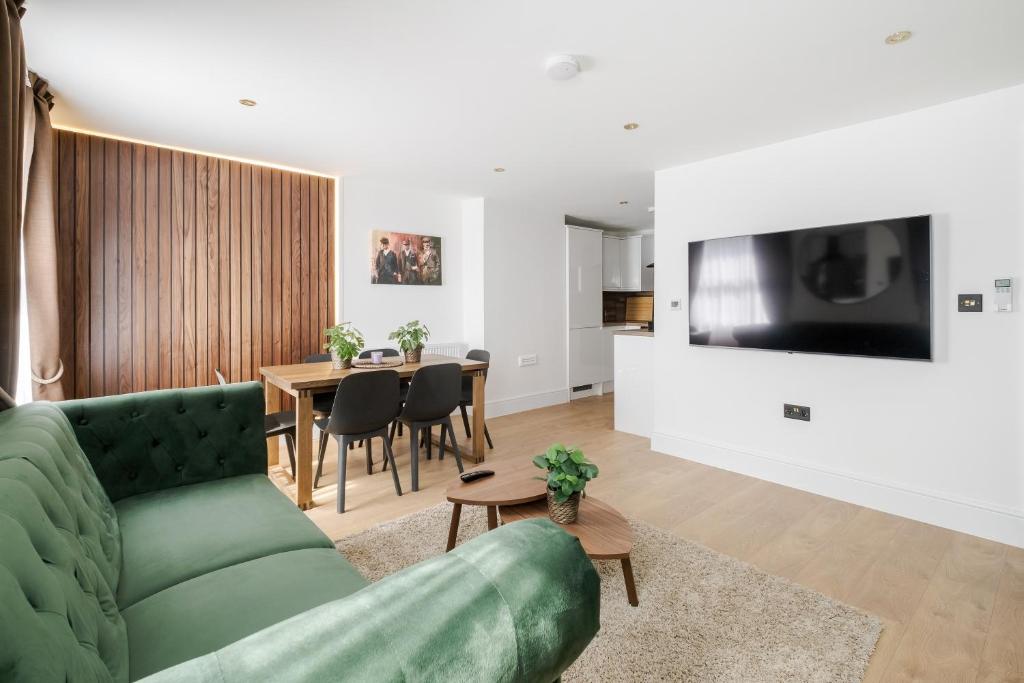 a living room with a green couch and a table at Luxury 1 Bedroom Apartment in Central London in London