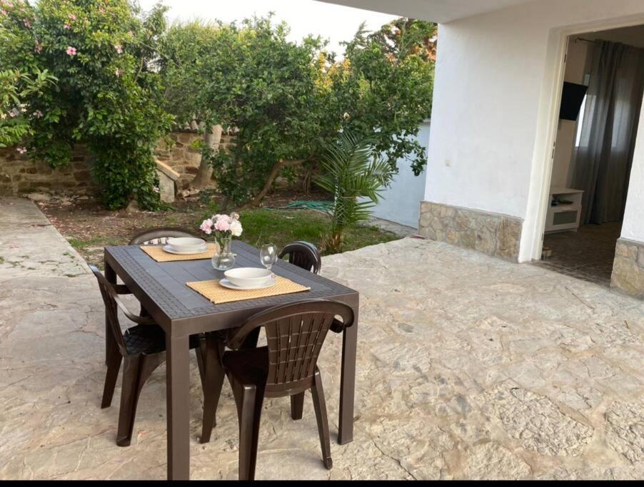 a wooden table and chairs on a patio at Bonita casa en Bolonia in Bolonia
