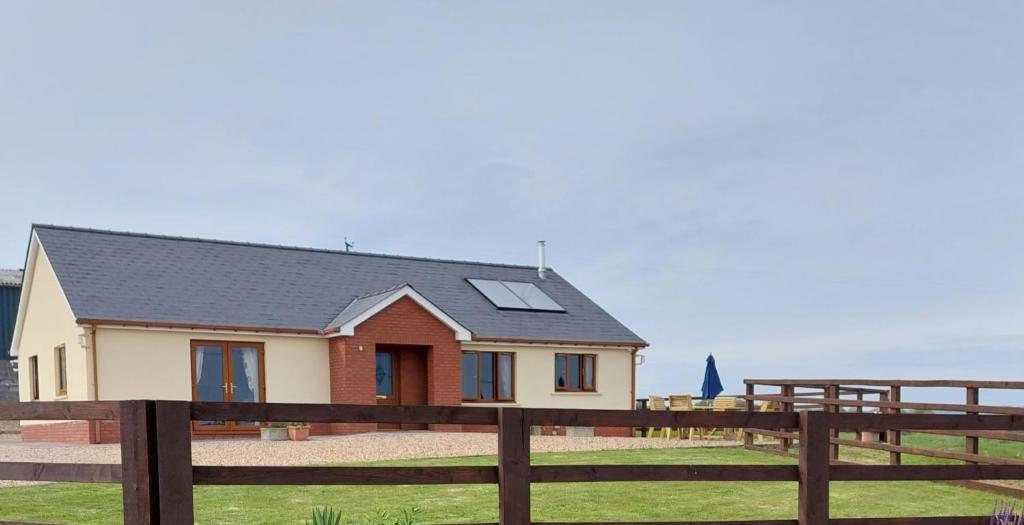 a house with solar panels on the roof at Sunny Bank- Countryside Escape with Private Hot Tub and countryside views in Carmarthen