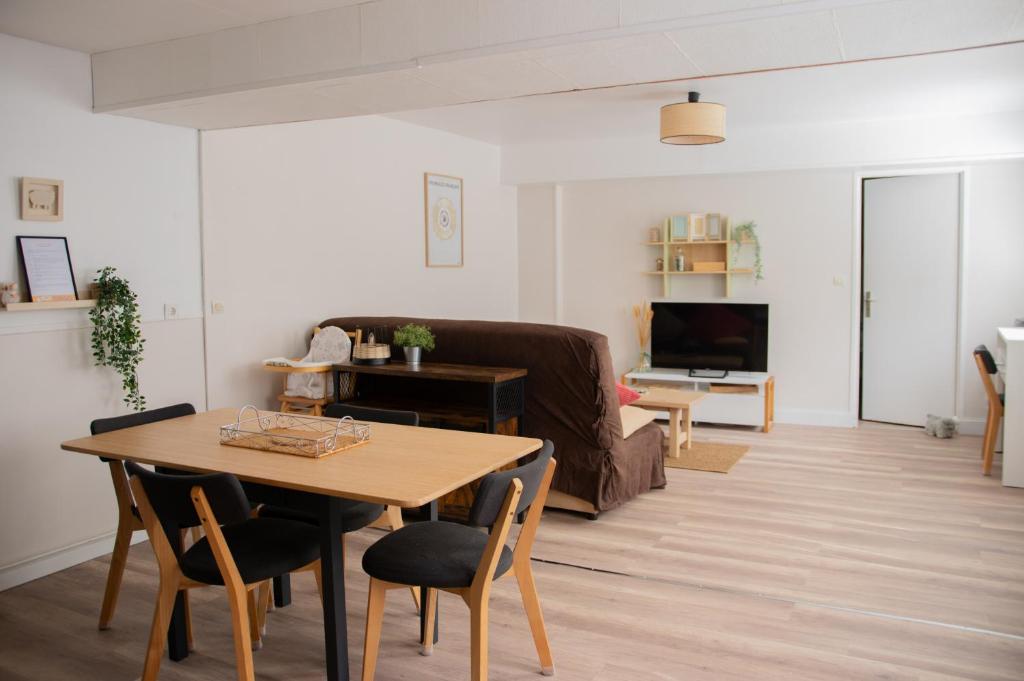 a living room with a table and a couch at Bergerie du centre ville - 1 chambre, équipement bébé, wifi et draps inclus in Dieppe