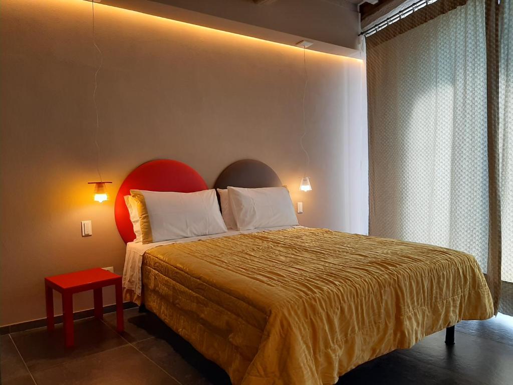 a bedroom with a large bed with a red headboard at Vistaperdue in Peccioli