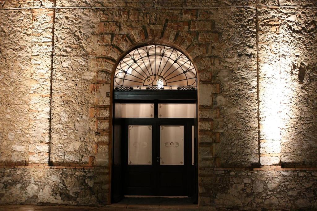 a black door in a brick building with a window at Antica dimora Palazzo Rossi in Marsico Vetere