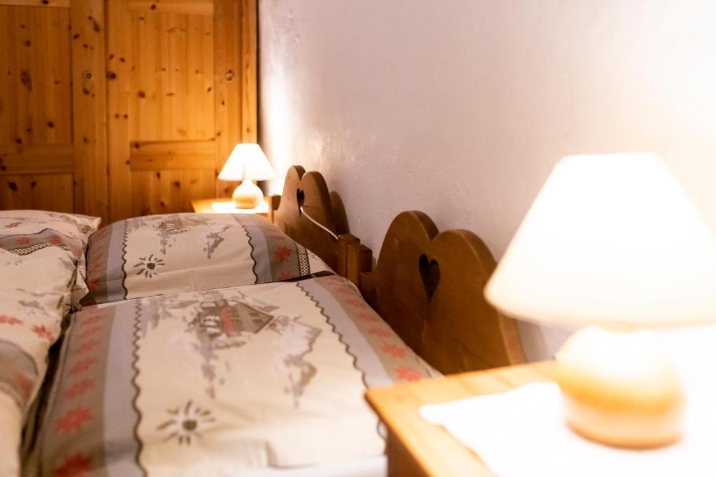 a bedroom with two beds and a table with a lamp at Aiguille de La Tza in Arolla