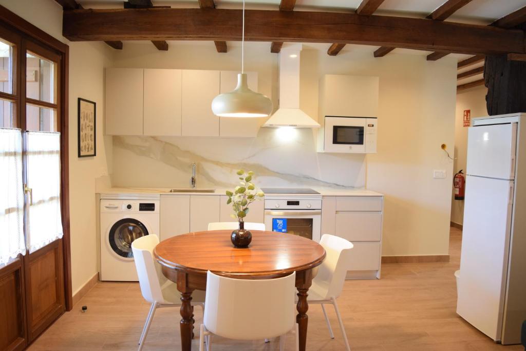 eine Küche mit einem Holztisch und weißen Geräten in der Unterkunft Peritxenea Landa Apartamentuak in Lesaka