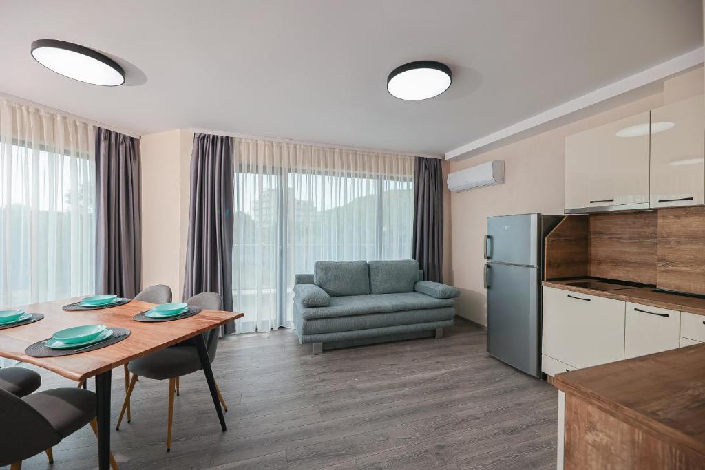 Lux Apartments Kranevo في كرانيفو: مطبخ وغرفة معيشة مع طاولة وأريكة