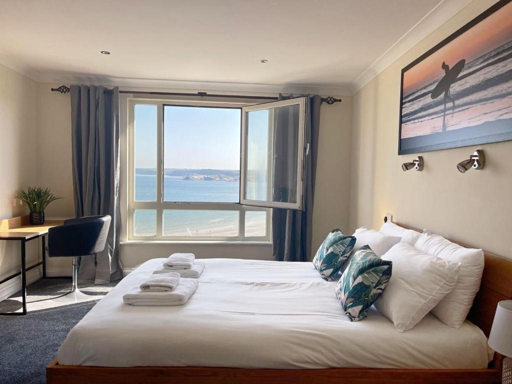 a bedroom with a bed with a view of the ocean at Chy Lowen in Newquay