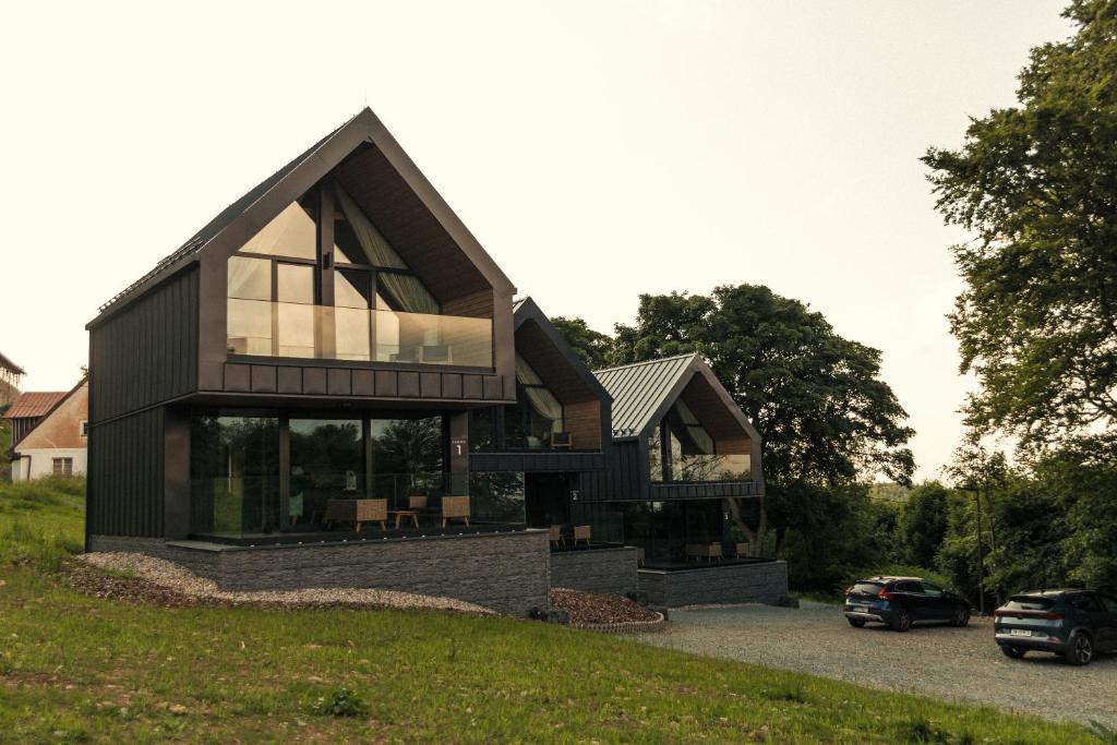 a house with a black roof and glass windows at Campo Resort in Duszniki Zdrój